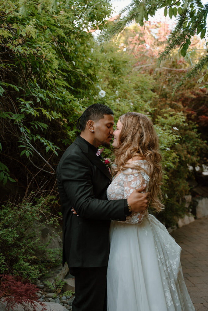 Bride and groom walking through a green leafy tunnel after their ceremony at las Cascadas